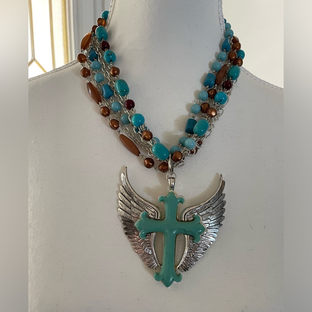 Silver tone multi chain necklace with turquoise and brown beads and pendant.